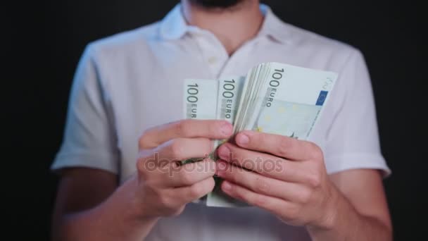 Egy férfi, fehér póló gazdaság készpénzben - Felvétel, videó