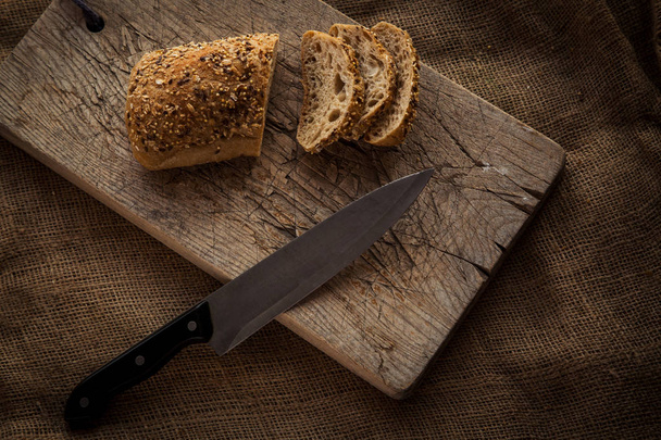 Wooden cutting board with sliced bread - Foto, immagini