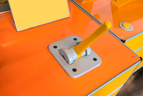 Controlador de palanca cerrado con mango amarillo en panel gris de
  - Foto, Imagen