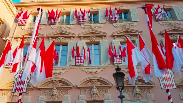 Wiele krajowych flagi Monaco na elewacji budynku podczas Narodowego dnia Monako, The Sovereign Prince's Day (Prince's Holiday) jest obecnie corocznie obchodzony w dniu 19 listopada - 4k wideo  - Materiał filmowy, wideo