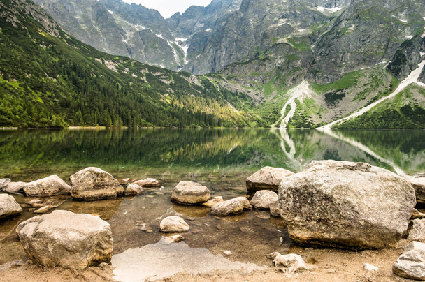 Landscape of mountain lake with clear water in emerald color in Tatra Mountains over Morskie Oko - Fotó, kép