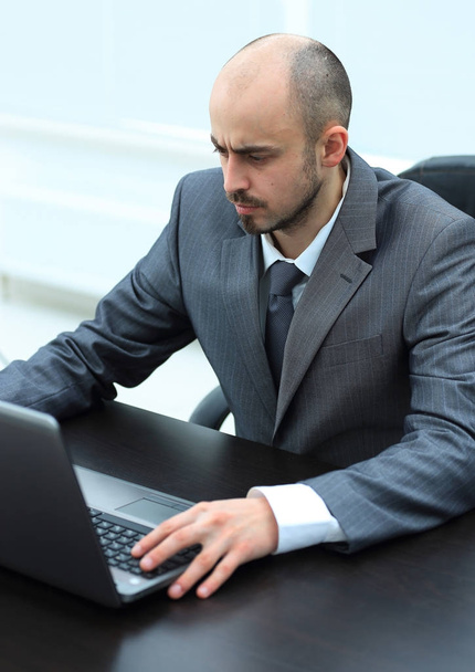 serious businessman working on laptop sitting at Desk - Фото, зображення