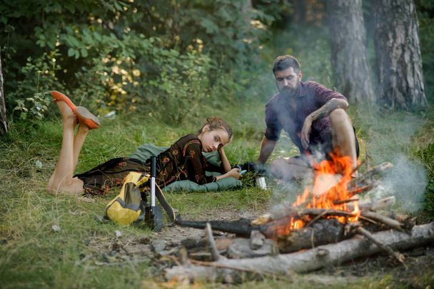 Woman and man relax at bonfire on green environment - Foto, Imagen