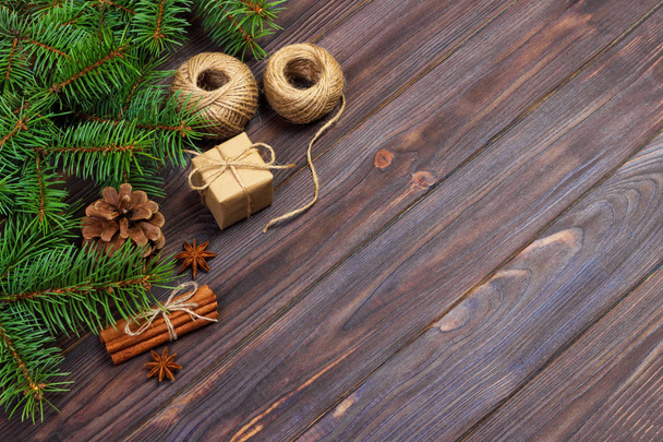 Noel hediyesi kutu. çam dalları ile tarçın ve anason rustik ahşap zemin üzerinde. düz yatıyordu. Mevsimlik selamlar kavramı. Kış tatil kavramı - Fotoğraf, Görsel