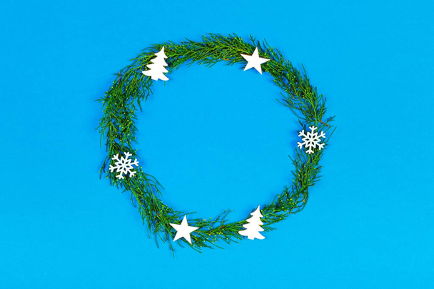 christmas or new year composition. christmas round frame made of winter decoration on blue background with copy space for text. holiday and celebration concept. flat lay. top view - Foto, imagen