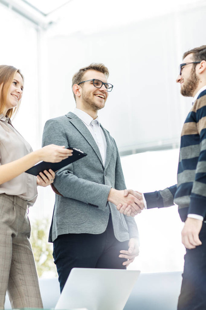 handshake business partners after discussion of the contract in a bright office. - Foto, Imagen
