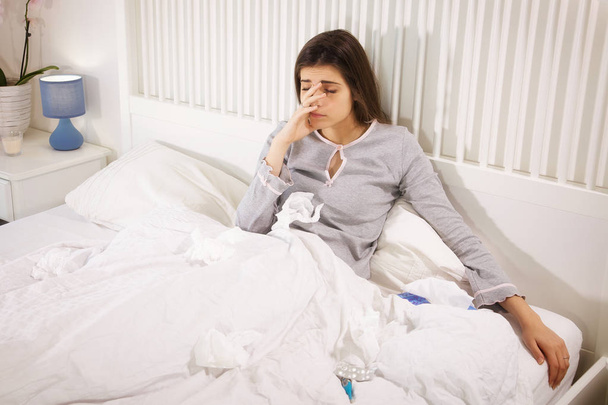 Ill woman in bed holding handkerchief feeling headache - Zdjęcie, obraz