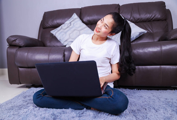young woman using a laptop computer in living room at home - Foto, imagen