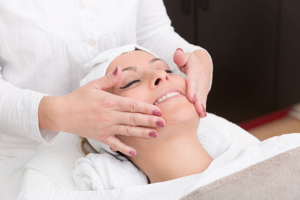 smiling woman gets a face massage - Zdjęcie, obraz