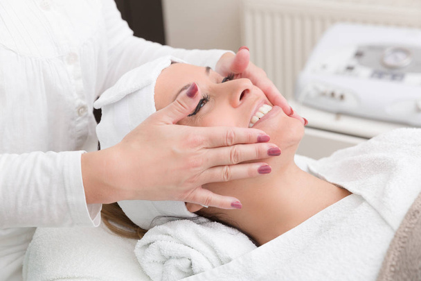 young woman gets a face massage - Foto, Imagem