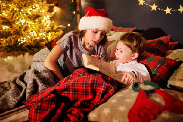 Un niño está leyendo un libro en la sala de Navidad.
 - Foto, imagen
