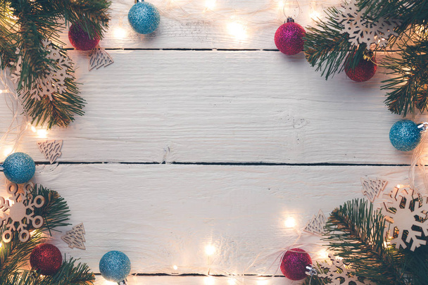 Foto van Kerstmis oppervlak met branden garland, takken van een spar, ballen - Foto, afbeelding