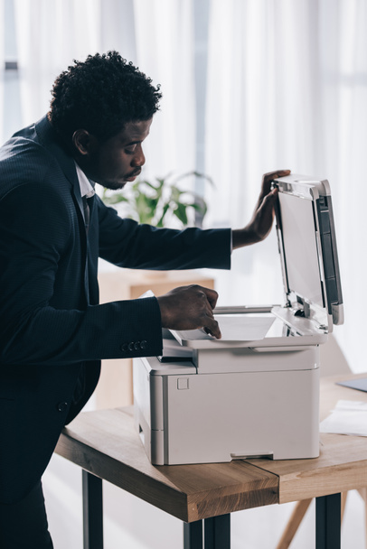 manager afro-americano utilizzando fotocopiatrice in ufficio
 - Foto, immagini