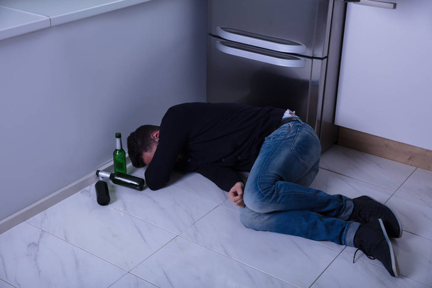 Man Lying On Floor In Kitchen - Foto, Imagen
