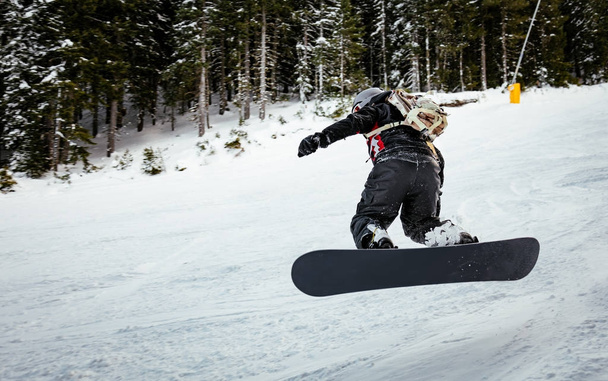 Snowboarder salta sulle piste di montagna e godersi una giornata invernale ghiacciata
. - Foto, immagini