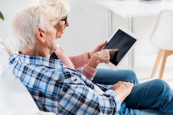 side view of senior couple using digital tablet with blank screen together - Photo, image