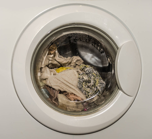 Washing machine is washing dirty laundry - Foto, afbeelding