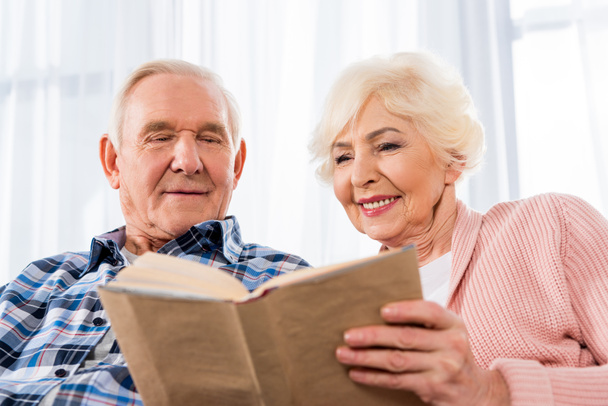glückliches Seniorenpaar liest gemeinsam Buch - Foto, Bild