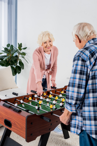 hermosa pareja de ancianos jugando futbolín en casa
 - Foto, imagen