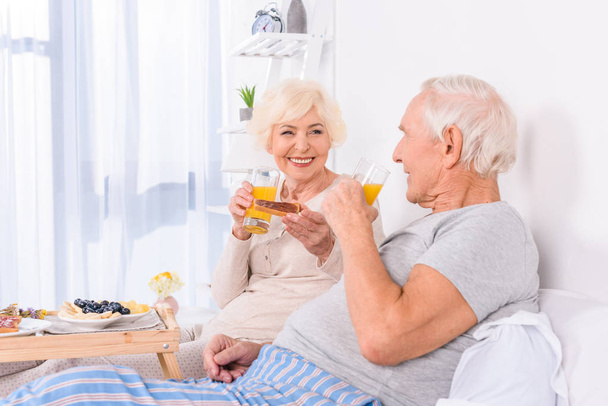 happy senior couple having breakfast in bed together at home - Foto, Bild