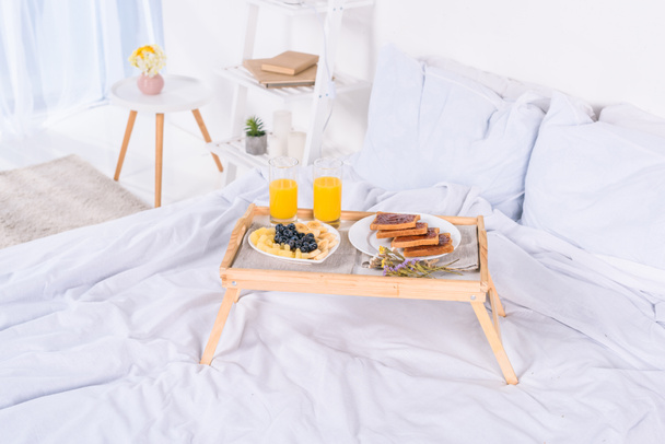 Ontbijt op bed op houten lade op ochtend - Foto, afbeelding