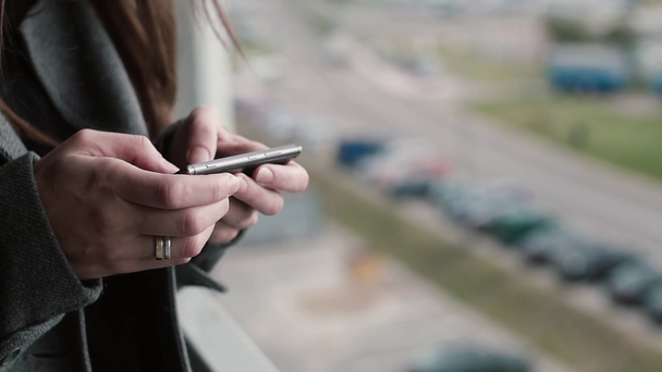 Vista de cerca de las manos femeninas sosteniendo el teléfono inteligente, Mujer joven navegando por Internet desde el teléfono móvil
. - Metraje, vídeo