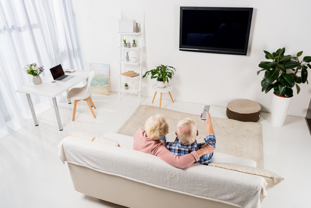 üst düzey çift evde rahat kanepede televizyon izlerken - Fotoğraf, Görsel