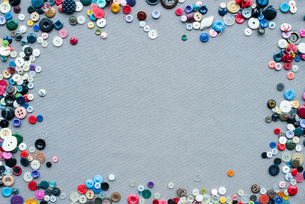 top view of colorful buttons frame on grey cloth background - Foto, Imagem