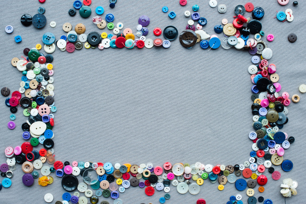 vista superior del marco de botones de colores sobre fondo de tela gris
 - Foto, Imagen