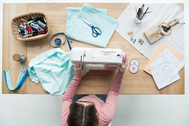vista superior de la costurera mujer en el lugar de trabajo con máquina de coser
 - Foto, Imagen