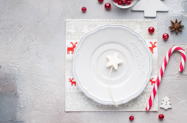 Χριστουγεννιάτικη διακόσμηση του τραπεζιού. Λευκό κενό πλάκα για το κείμενό σας. Αστεία χαρτοπετσέτες με ταράνδους, Αϊ-Βασίλη. Επίπεδη lay, κορυφαία προβολή - Φωτογραφία, εικόνα