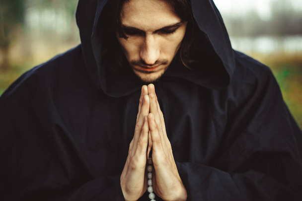 μοναχός σε ρόμπες προσεύχεται στο δάσος - Φωτογραφία, εικόνα
