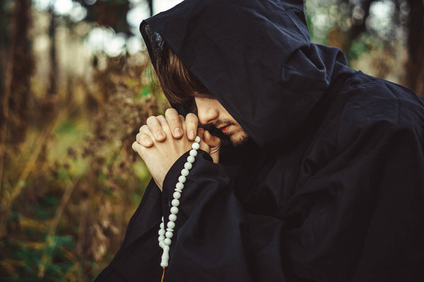 Монах в мантиях, молящийся в лесу
 - Фото, изображение