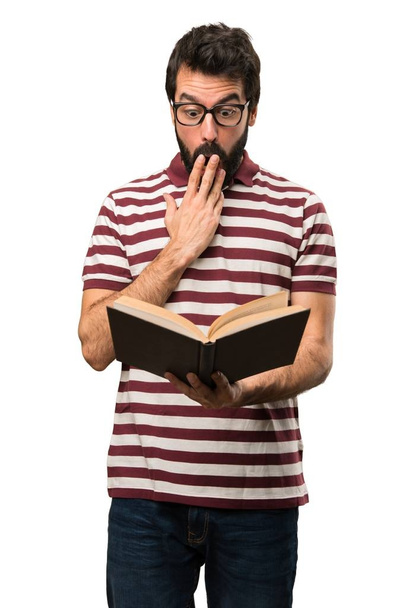 Zaskoczony mężczyzna w okularach z książką - Zdjęcie, obraz