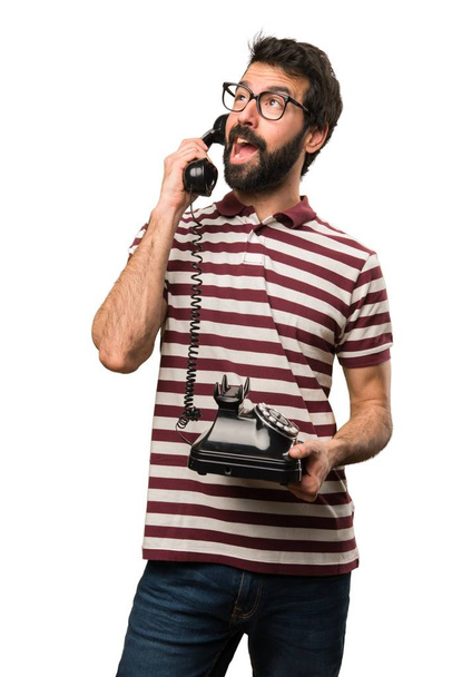 Man with glasses talking to vintage phone - 写真・画像