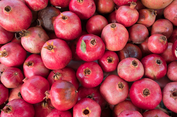 Viele rote reife Granatäpfel liegen auf dem Tisch - Foto, Bild