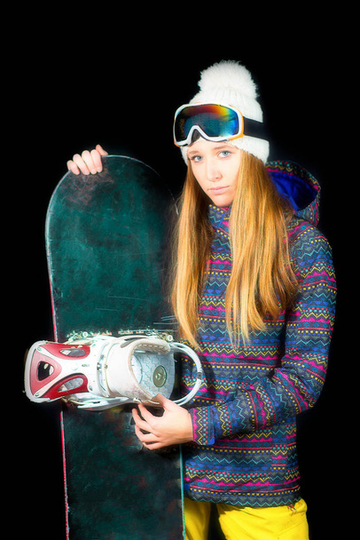Спортивная девушка с длинными светлыми волосами с сноубордом на черной студии
  - Фото, изображение
