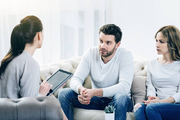Nice depressed couple looking at their therapist - Foto, imagen