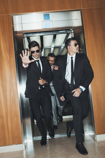 guardaespaldas obstruyendo paparazzi cuando celebridad saliendo de ascensor
  - Foto, imagen