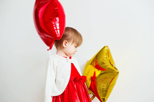 Cute little girl playing with star shaped balloons in front of w - Photo, Image