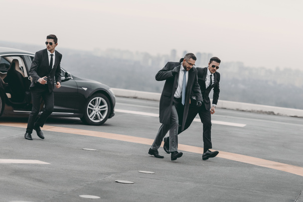 bodyguards protecting businessman on his way from car - Foto, imagen