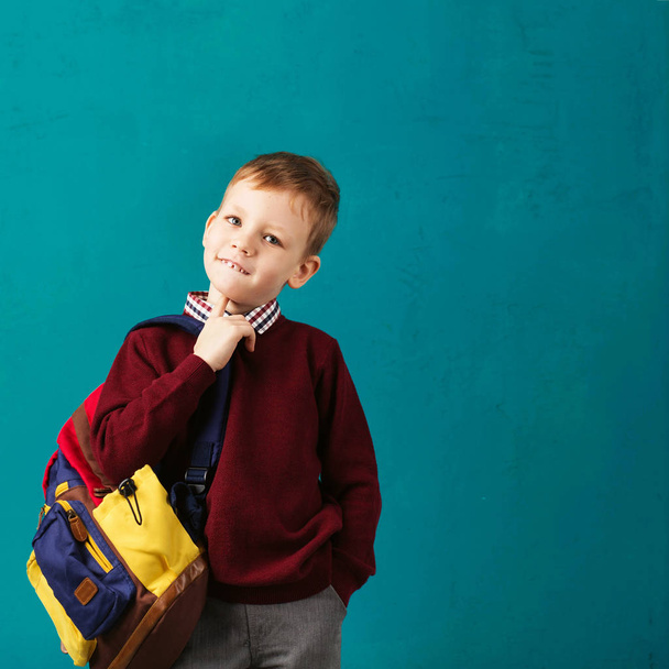 Cheerful thoughtful little school boy in school uniform with big - Photo, Image