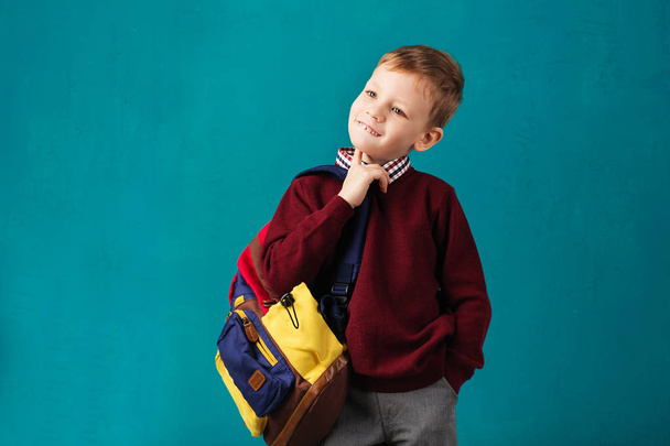 Allegro pensieroso piccolo ragazzo della scuola in uniforme scolastica con grande
 - Foto, immagini