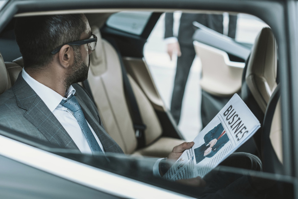 businessman sitting in a car and holding newspaper - Photo, Image