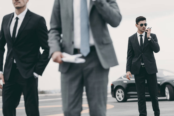 cropped image of bodyguards and businessman walking on helipad  - 写真・画像