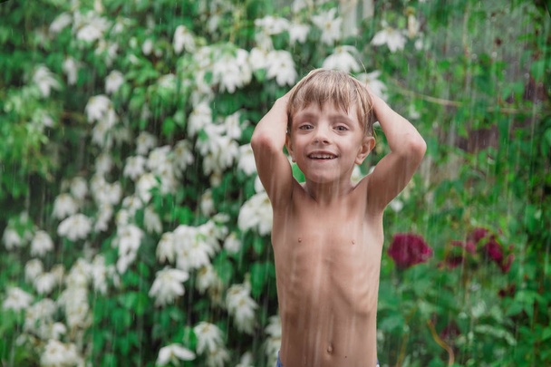 Cheerful, excited baby having fun, running wet under rain - Photo, Image