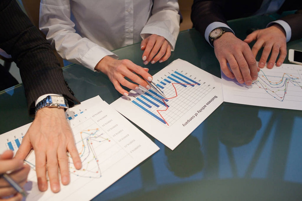 Image of hands pointing at business document during discussion at meeting. - Photo, Image