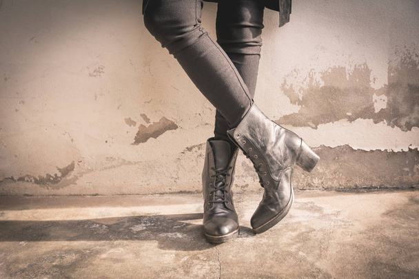 A woman legs wearing black boots with high heel. Sepia tone. - Valokuva, kuva