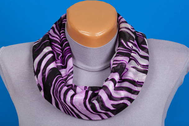 Сиреневый шарф на манекене изолирован на синем фоне
. - Фото, изображение