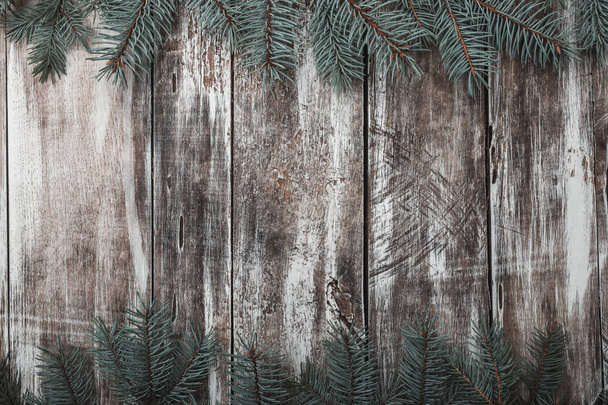 Old wooden background. Green fir branches at the top and bottom. Space for congratulation message of Xmas, Christmas and New Year. Rustic. Xmas and Happy New Year composition. Flat lay, top view - Photo, Image